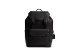Front view of the black Coach Track Backpack featuring a leather flap with dual speed-clip fasteners, a front zip pocket, and side compartments.