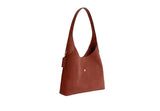Three-quarter side view of the brown Coach Brooklyn hobo bag showing the wide shoulder strap and leather hangtag.