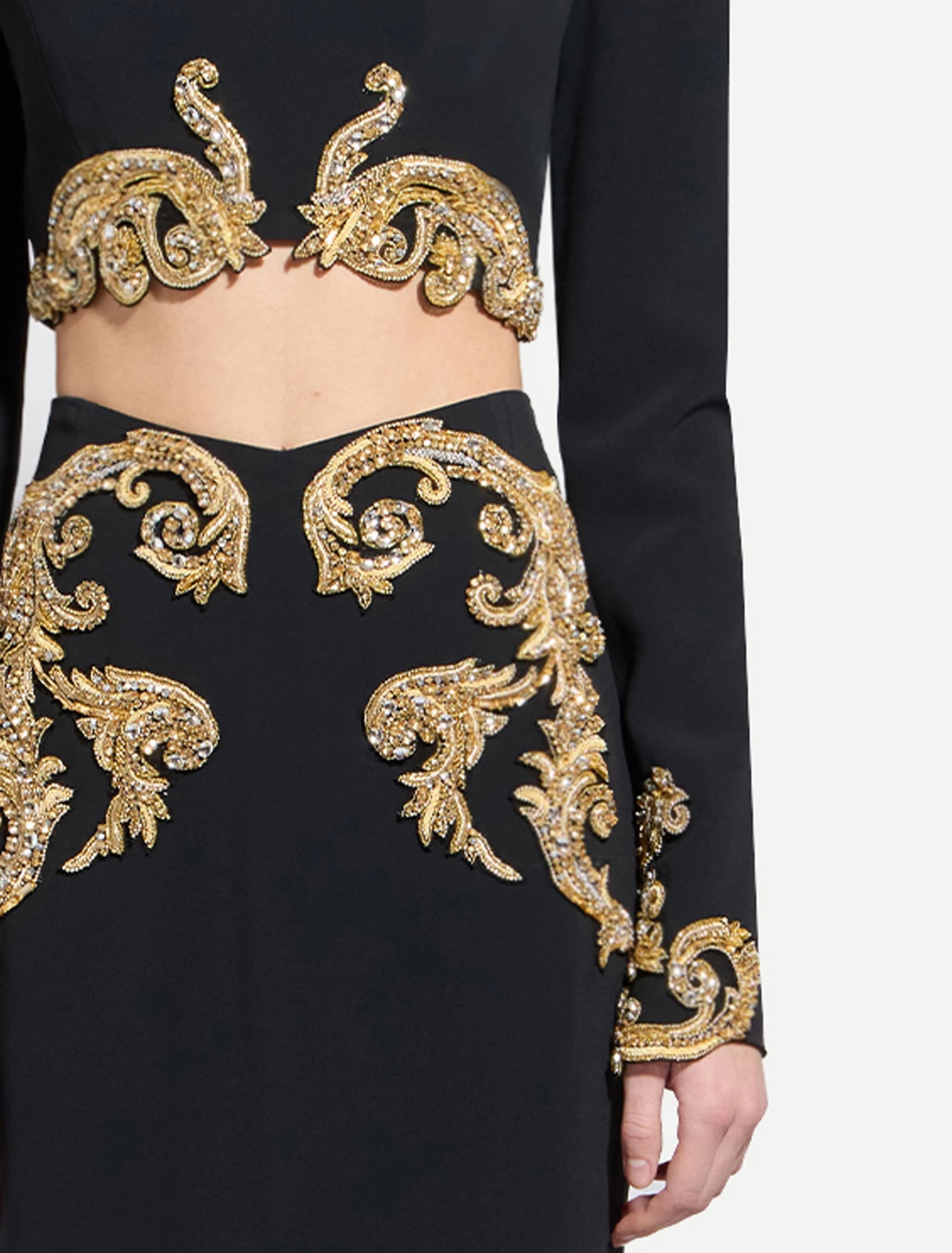 Black long-sleeved crop top and matching skirt with elaborate gold-toned beaded and crystal baroque embroidery on bust, skirt