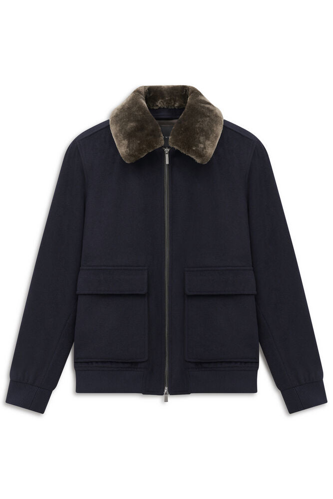 Navy blue bomber jacket with a dark brown faux fur collar, full zip closure, and two front flap pockets.
