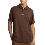 Brown short-sleeved polo shirt with a collared neckline, two-button placket, and an embroidered gold-toned logo on the chest.