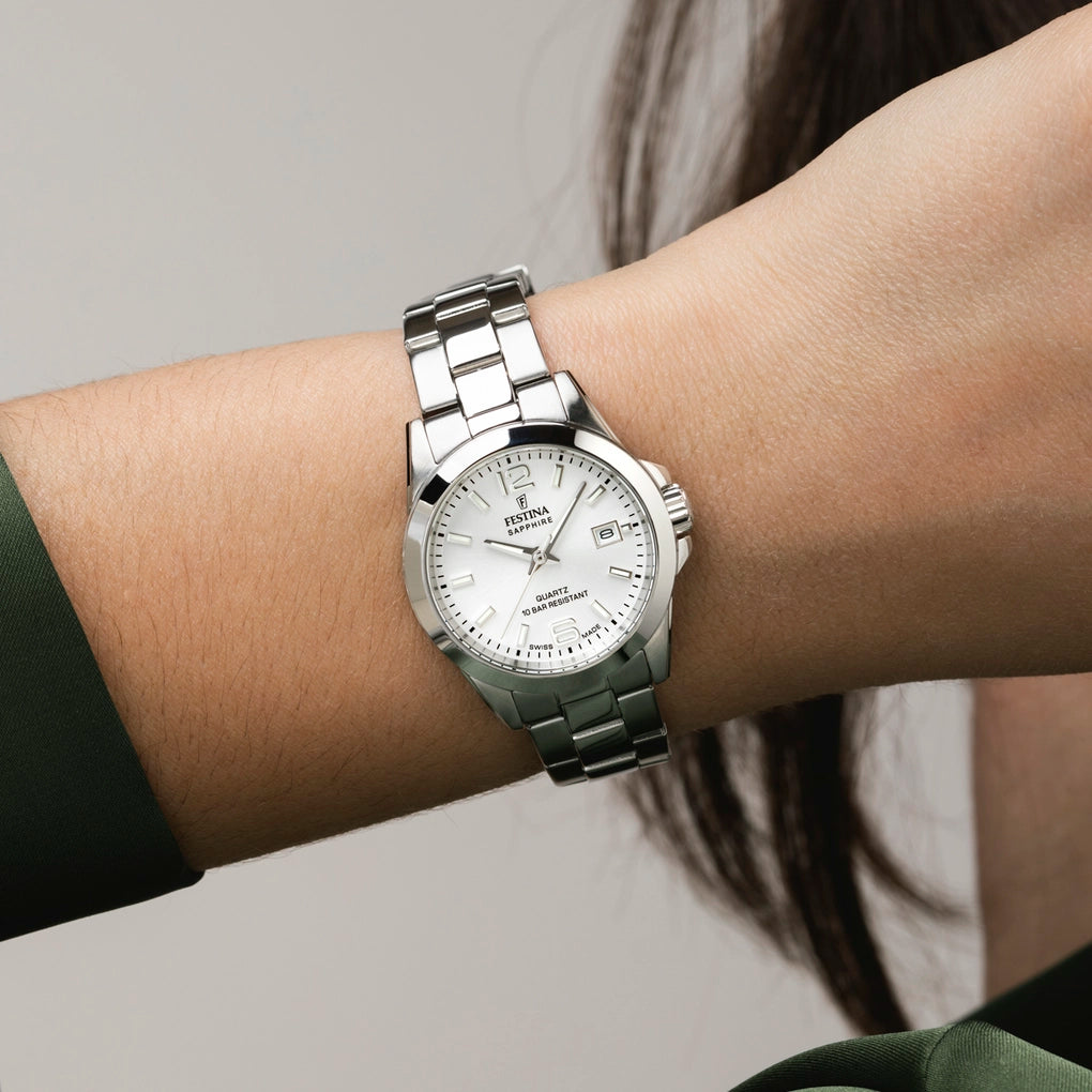 Silver-toned ladies' watch with a round case, white dial, silver-toned hands, dash hour markers, date window, and metal link