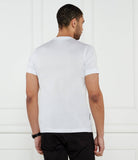 White crewneck t-shirt, back view. It has short sleeves and a small dark tag on the lower left side seam.