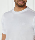 White crewneck t-shirt with short sleeves and a ribbed collar. Features a small white embroidered logo on the left chest.