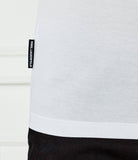 White t-shirt with a black vertical 'KARL LAGERFELD' tag on the left side seam and a stitched bottom hem.