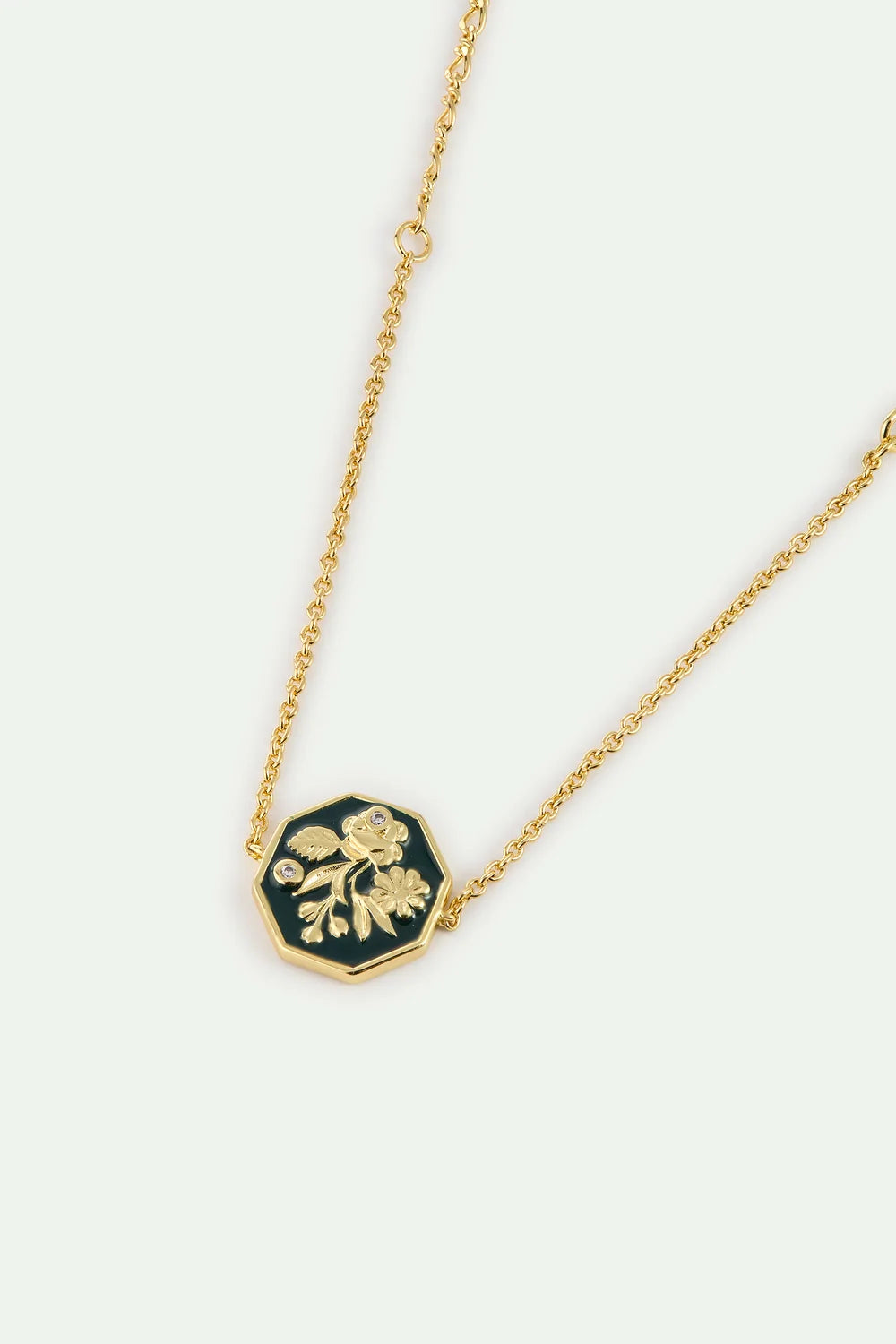 Gold-toned chain bracelet with an octagonal dark green enamel pendant featuring a gold-toned floral design and two clear ston
