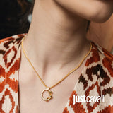 Gold-toned necklace with a thin chain and a circular pendant. The pendant is a textured ring, with a smooth, intertwined knot