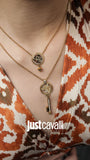 Two gold-toned necklaces with clear stones. One: black/white tiger head charm. Other: gold-toned tiger head charm and a key.