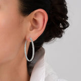 A large, silver-toned hoop earring with clear crystals set along both the outer and inner edges.