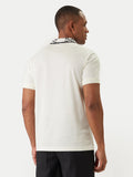 Champagne knit polo shirt with short sleeves, ribbed cuffs, and a white collar featuring a black repeating pattern.
