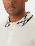 Champagne polo shirt with a white and black 'KL' monogram knit collar, two buttons, and embroidered 'KARL LAGERFELD' logo.