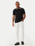 Black short-sleeve polo shirt with a white collar featuring a black houndstooth-like pattern and a three-button placket.