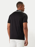 Black short-sleeve polo shirt with a patterned black and white collar featuring a thin white stripe.