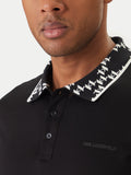 Black polo shirt with a black and white patterned collar featuring "K" logos, a two-button placket, and "KARL LAGERFELD" text