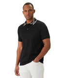 Black short-sleeved polo shirt with a white monogrammed collar, three black buttons, black chest logo, and a white stripe on