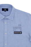 Light blue short-sleeved shirt with white buttons. Features tone-on-tone La Martina embroidery and a dark blue 'ARGENTINA' pa