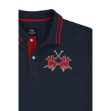 Navy blue pique polo shirt with red striped collar, red inner placket, white buttons, and a red embroidered polo player logo.