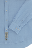 Light blue linen long-sleeve button-up shirt with white buttons, buttoned cuffs, a fabric label, and a curved hem.