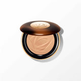 Lancome powder bronzer compact with a dark tortoiseshell-effect lid, gold-toned rim, and light bronze powder with a wave patt