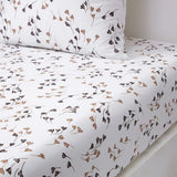 White duvet cover and pillow case with scattered dark brown and beige abstract plant motifs.