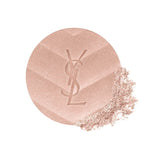 Circular shimmery rose gold-toned powder with an embossed YSL logo and chevron pattern. Loose powder is visible on the bottom
