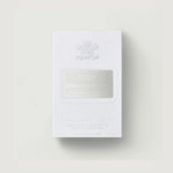 White perfumed oil box with an embossed crest and a silver-toned label featuring 'CREED SILVER MOUNTAIN WATER' text.