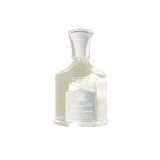 Clear glass bottle of Creed perfumed oil with a light yellow liquid, silver-toned cap, and a silver and white label.