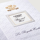 White box with embossed crowns, a gold-toned crest, and a label with silver-toned textured border and "Creed Spice and Wood".