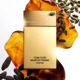 Matte gold rectangular perfume bottle with a gold-toned vertically ridged cap. Black text reads 'TOM FORD NOIR EXTREME PARFUM