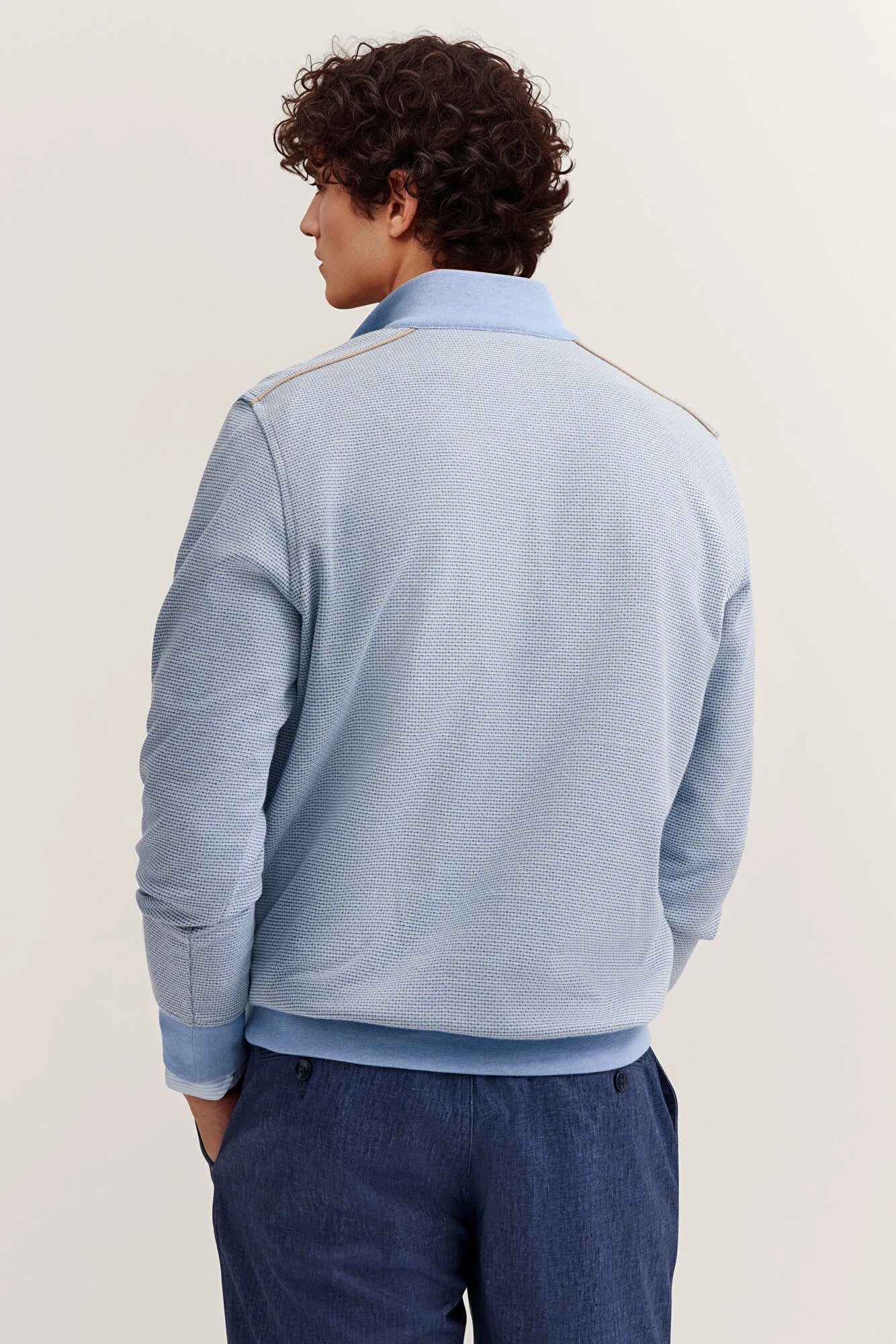 Light blue textured sweatshirt with a smooth light blue polo collar, tan piping on shoulders, ribbed cuffs and hem.