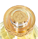 Close-up of a gold and clear cosmetic bottle cap with a brand logo on a white background.