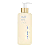 Pale yellow translucent rectangular body wash bottle with a gold-toned collar and white pump dispenser, featuring blue text.