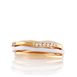 Set of three gold-toned wave rings, one with white enamel, another with a row of clear stones.