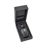 Faceted perfume bottle, dark green-to-black gradient, gold-toned cap, bull logo, silver 'X', in open black box with quilted l