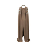 Back view of brown high-neck embroidered evening gown with attached floor-length cape sleeves and floral detailing.